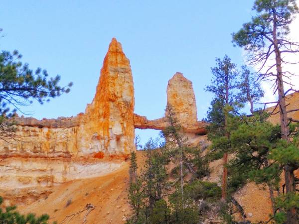 alt="קשת-טבעית-מאבן-חול-ומגדלים-חומים-הפארק-הלאומי-ברייס-קניון">