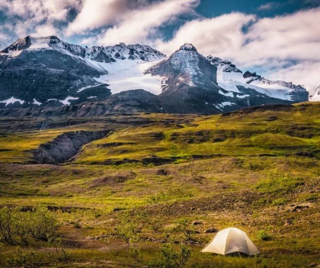 alt="אוהל-מול-הרים-מושלגים-הפארק-הלאומי-סנט-אליאס-אלסקה">