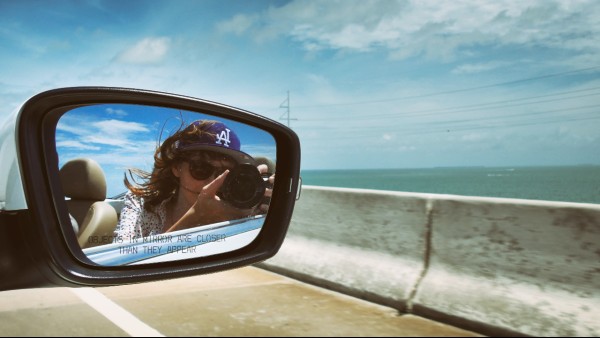 alt="השתקפות-של-אישה-מצלמת-במראת-רכב-על-גשר-בפלורידה-קיז">