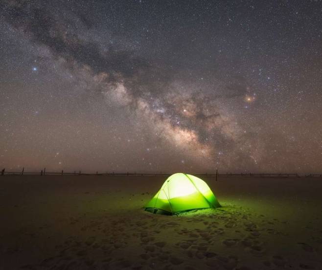 alt="אוהל-ירוק-בלילה-באתר-קמפינג-ארצות-הברית-ומעל-הכוכבים">