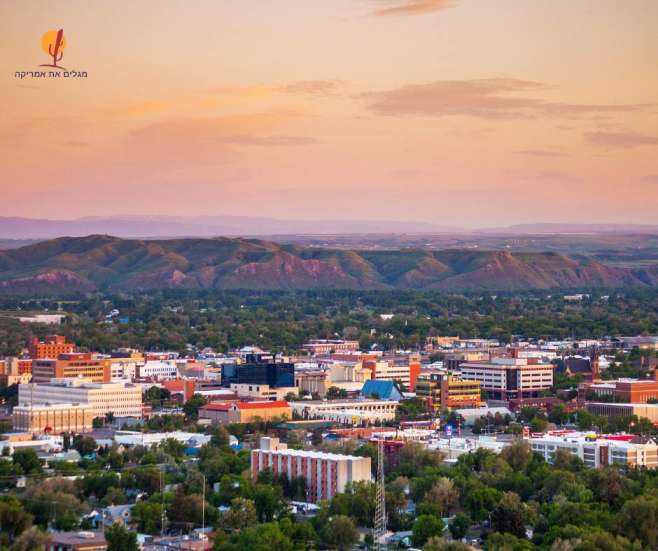 alt="מבט-אווירי-על-בנייני-העיר-בילינגס-וההרים-ברקע-בזמן-שקיעה-מונטנה">