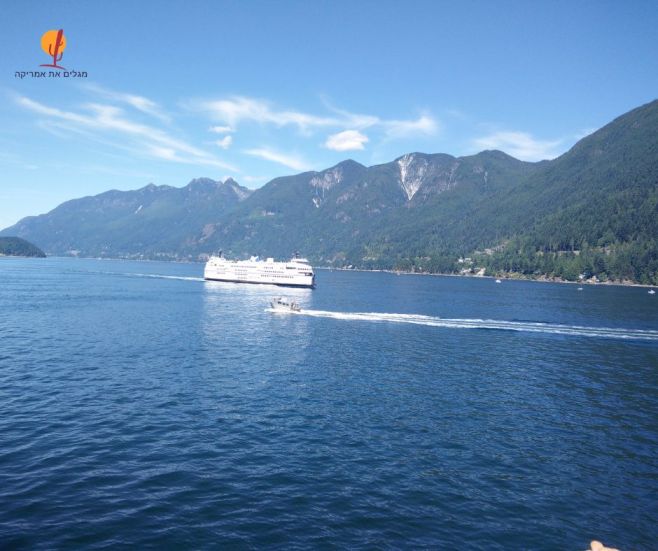 מעבורת של חברת BC Ferries שייטת במים בדרך לאי ונקובר על רקע הרים ונוף ימי